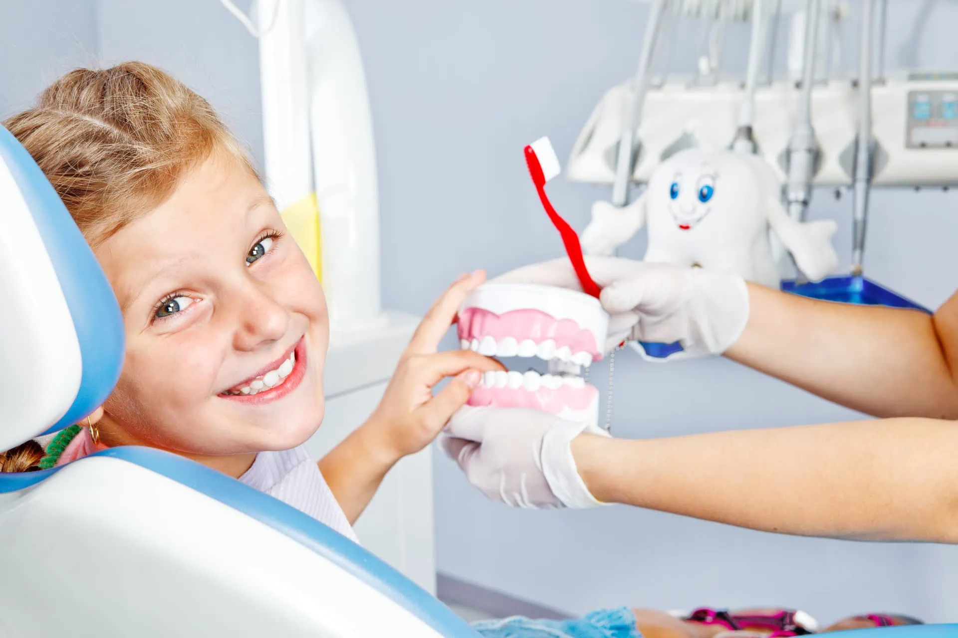 A parent and child smiling together at the dentist